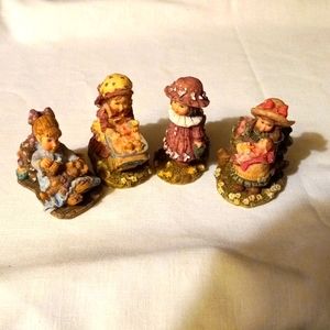 Four ceramic little dolls.